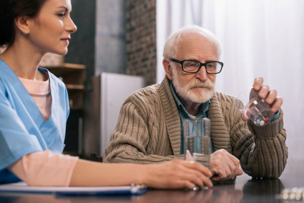 istock Nurse by senior man taking medications 932844906