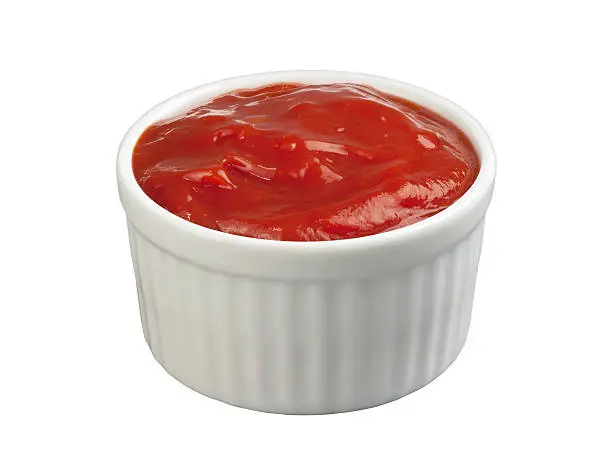  Tomato Ketchup  in a white ceramic ramekin isolated on white with a clipping path. The image is photographed at an angle from above, and is full focus from front to back.  Ketchup is a condiment used to  enhance the flavor of french fries, hotdogs, and hamburgers.