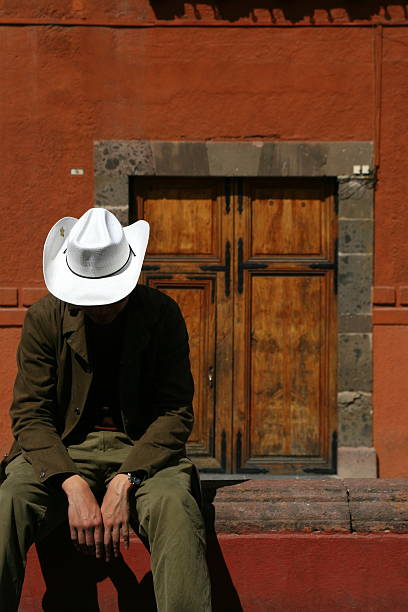 Close up of a white cowboy hat and rope in a country fence