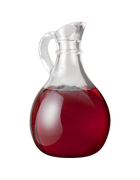 Red Wine Vinegar Red Wine Vinegar in a glass cruet.  The image is shown as an angle and is in full focus from front to back. Vinegar can be used as a condiment or as an ingredient in cooking recipes.  It is a liquid consisting mainly of acetic acid. vinegar bottle stock pictures, royalty-free photos & images