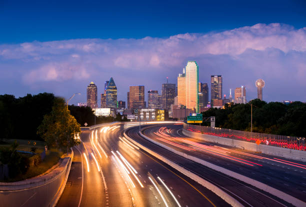 The Race Through Dallas, Texas Long exposure of evening rush hour with cars racing in and out of Downtown Dallas, Texas on a stormy night. interstate photos stock pictures, royalty-free photos & images