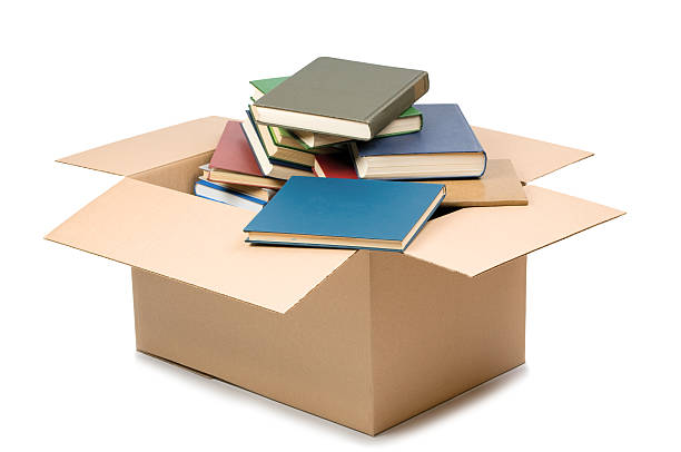 Cardboard box and books stock photo