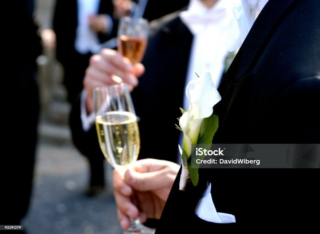 Tuxedo-clad men drinking champagne and mingle at a wedding event  Celebration Event Stock Photo