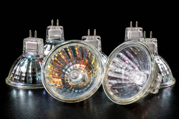 istock Halogen bulb in a reflective shade. Lighting accessories on a dark tole. Black background. 932924988