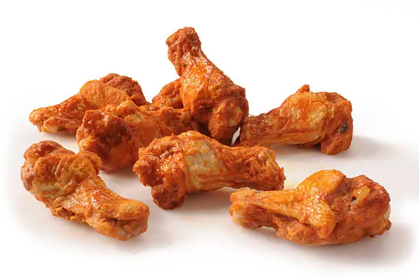 Photo of Lightly sauced buffalo chicken wings isolated on white