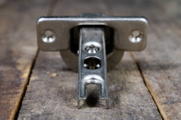 istock A woodwork hinge on a wooden workshop table. Joinery accessories for the construction of furniture in a carpentry workshop. Black background. 932955948