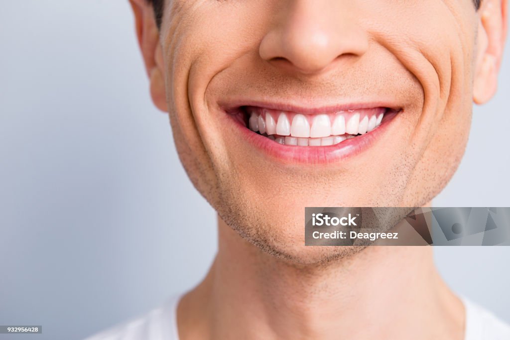 Close up cropped half face portrait of attractive, trendy, stylish, experienced, brunet, toothy man with wide beaming smile and healthy teeth, isolated on grey background Smiling Stock Photo