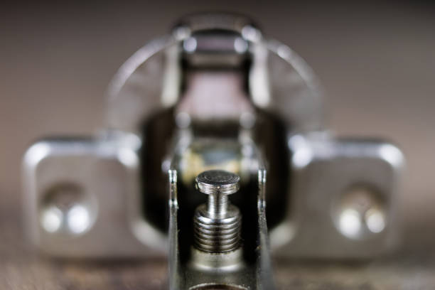 istock A woodwork hinge on a wooden workshop table. Joinery accessories for the construction of furniture in a carpentry workshop. Black background. 932957234