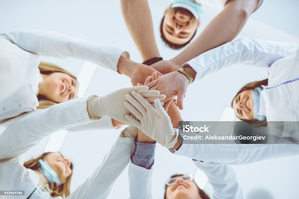 Multiethnische Ärzteteam Stapeln Hände im Kreis für den Erfolg - Lizenzfrei Arzt Stock-Foto