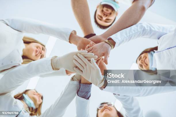 Multiethnische Ärzteteam Stapeln Hände Im Kreis Für Den Erfolg Stockfoto und mehr Bilder von Arzt