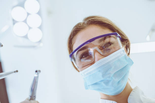 istock Skillful Young Female Dentist is Treating Patient Teeth 932978372