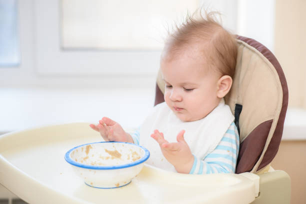 istock Kid eats porridge hands of the plate 932998150