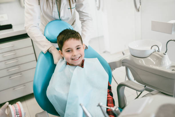 lächelnde junge immer bereit für die regelmäßige zahnärztliche kontrolle bis in klinik - dentists chair dentist office chair orthodontist stock-fotos und bilder