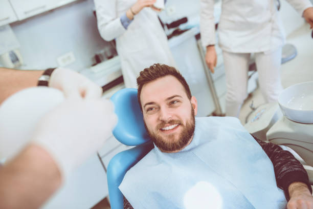 istock Young Smiling Patient in Dental Clinic Preparing for Teeth Exam 933019372