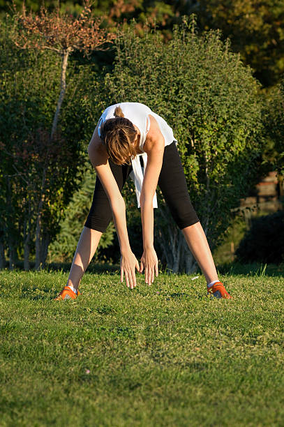Young Woman Stretching at a Park stock photo