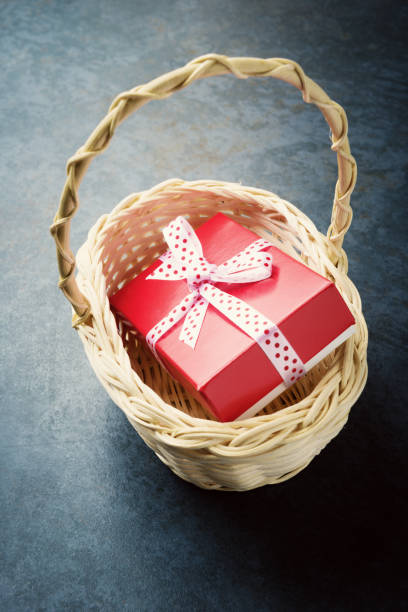 istock Red gift box in basket over stone background. 933032818