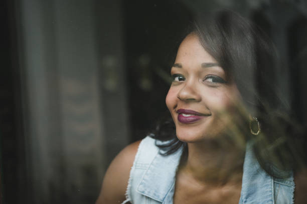istock Positive woman behind window glass 933035108