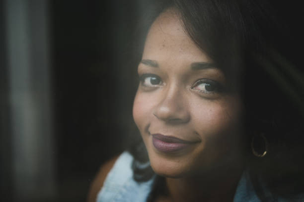 istock Positive woman behind window glass 933035144