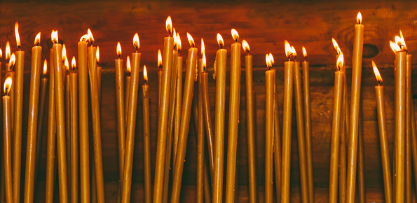 many burning wax candles in the temple