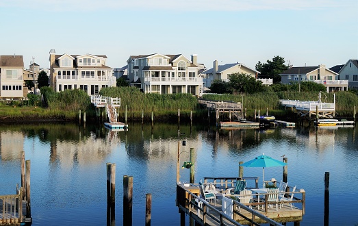 Avalon, New Jersey – July 18, 2015: A row of luxury waterfront summer homes on the back bay in Avalon, New Jersey during a quiet summer sunset.