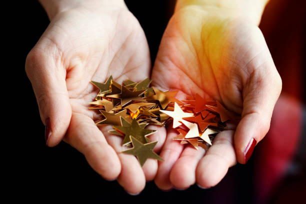 istock Girl holding gold star confetti 933094216