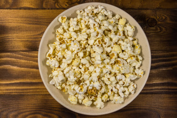 istock Bowl with popcorn on wooden table 933096958