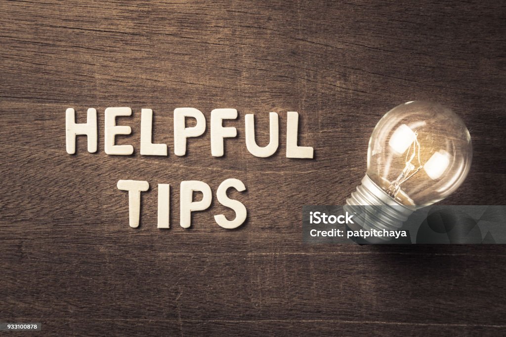 Helpful Tips Helpful Tips text with glowing light bulb on wood texture Advice Stock Photo