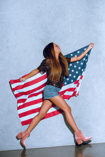 happy african american woman with american flag in hands