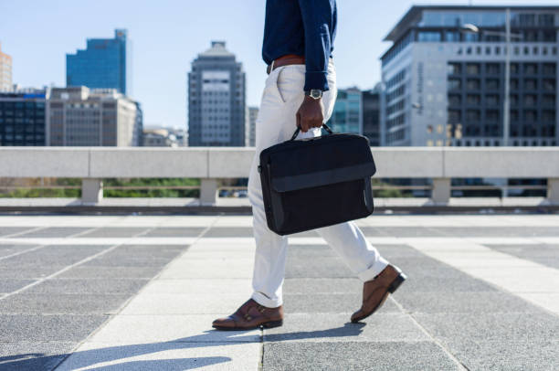 Businessman carrying his laptop bag walking through the city. stock photo