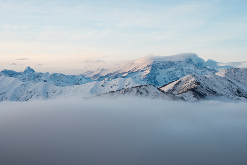 Winter panorama of the Italian Alps: Monte Rosa massif seen from the Biella pre-Alps. At sunset the fog rises from the valley bottom.
