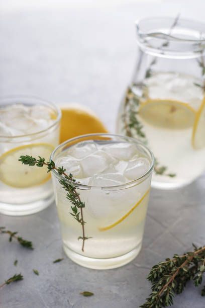 istock Two glasses with homemade lemonade and thyme on the stone table. 933120062