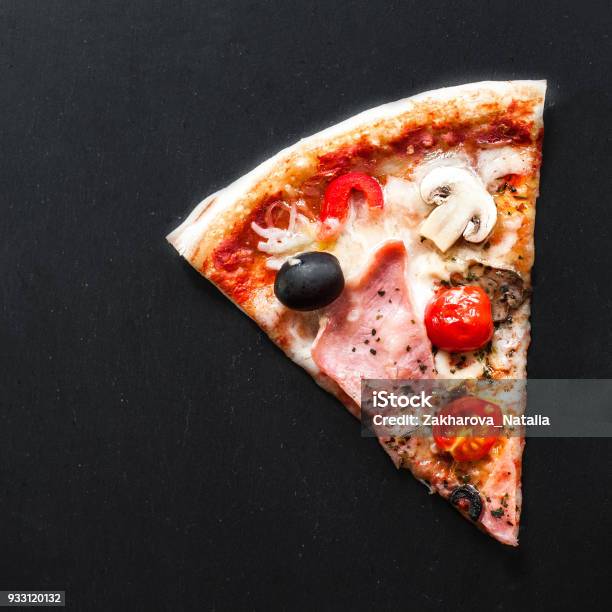 Slice Of Italian Classic Pizza With Salami Ham And Bacon Cheese Pepper And Olives Over Black Background With Copy Space Stock Photo - Download Image Now