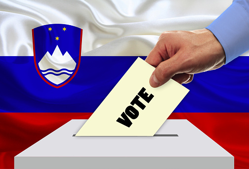Man voting on elections in Slovenia front of flag