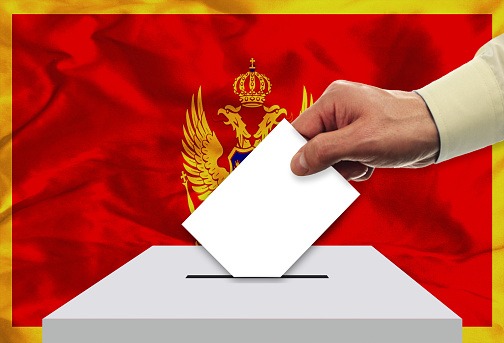 Male inserting flag into ballot box - Montenegro