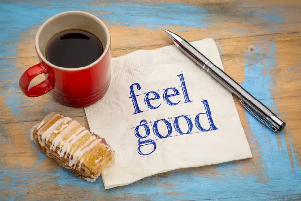 feel good - handwriting on a napkin with a cup of coffee and cookie