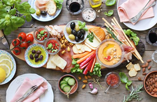 istock Appetizers table with cured meat, gazpacho soup, jamon, olives, cheese, hummus and vegetables. Mediterranean diner table with tapas selection. 933134594