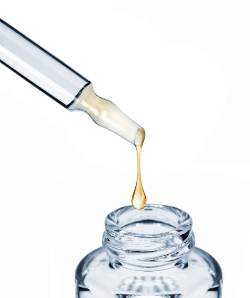 istock Drop falls from a cosmetic ampoule into a bottle close-up, isolated on white background 933141022