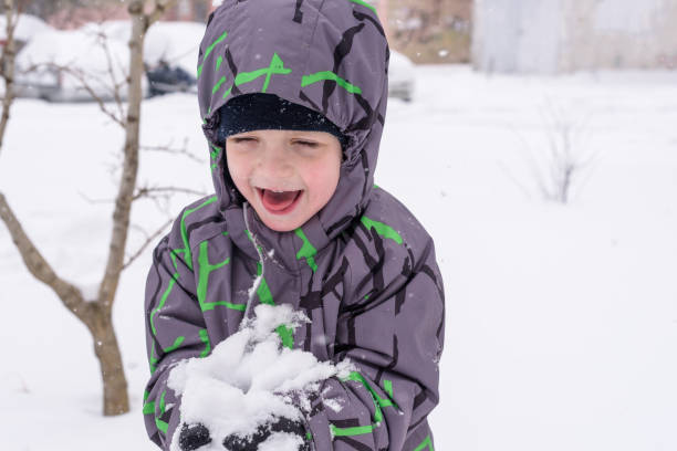 istock The boy holds snow in hands 933141134