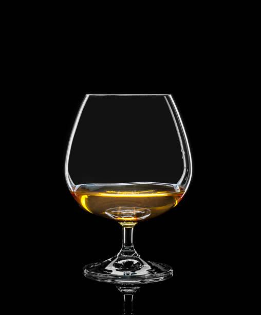 istock Cognac glass with drink on black 933154108