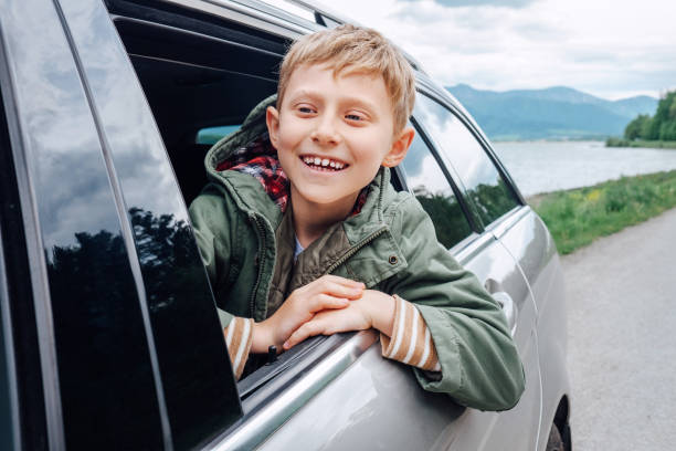 istock Happy boy look out from auto window 933159900