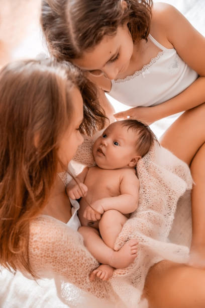 istock Older sister holding a newborn baby. 933163470
