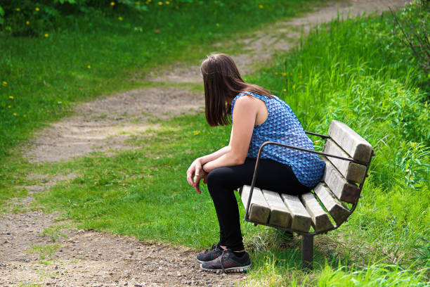 istock A young woman rests on a bench as a trail winds around her 933172650