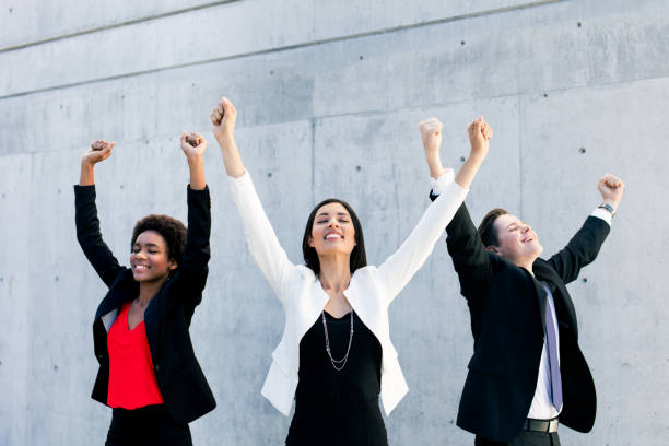 istock Multi-ethnic group of three standing and raising arms 933175702