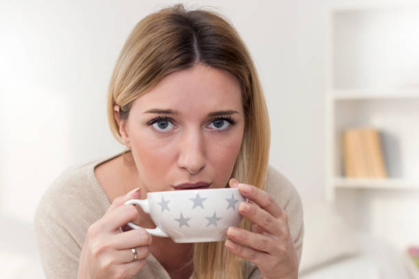 istock Young woman in PMS drinking a tea 933186990