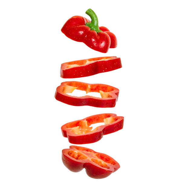 Creative concept with flying red paprika Sliced floating pepper. Levity capsicum Creative concept with flying red paprika. Sliced floating pepper. Levity capsicum vegetable isolated on white background pepper stock pictures, royalty-free photos & images