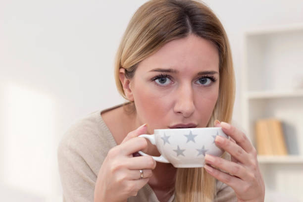 istock Young woman in PMS drinking a tea 933187020