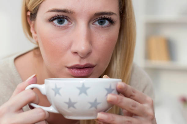 istock Young woman in PMS drinking a tea 933187256