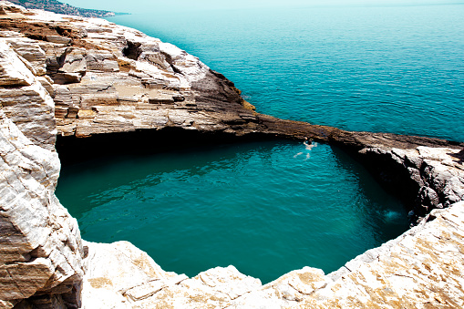 Man swimming alone in natural pool Giola in Greece. Wonder of nature