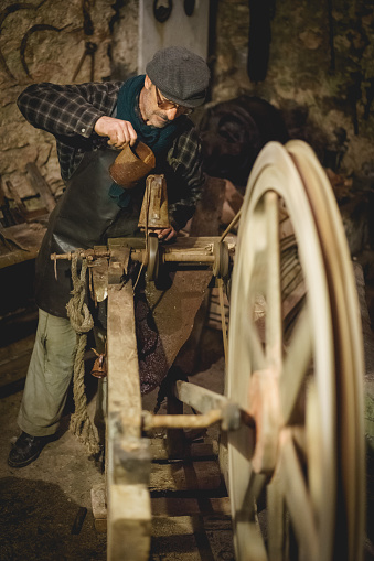 Rasiglia (Foligno), Italy - January, 2018. Man working on an old machinery during a living Christmas Nativity scene reenactment. Portrait format.