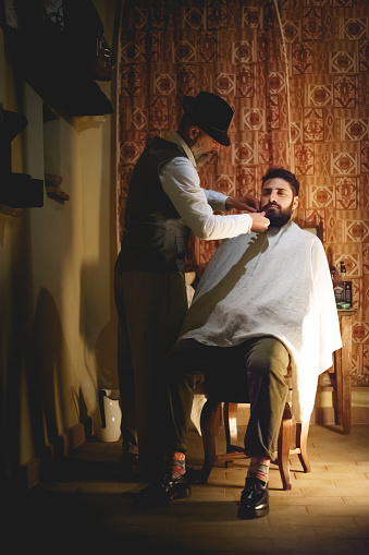 Foligno, Italy - January, 2018. A vintage barber during a living Christmas Nativity scene reenactment. Portrait format.